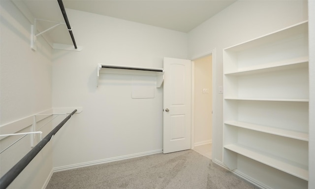 walk in closet featuring light colored carpet