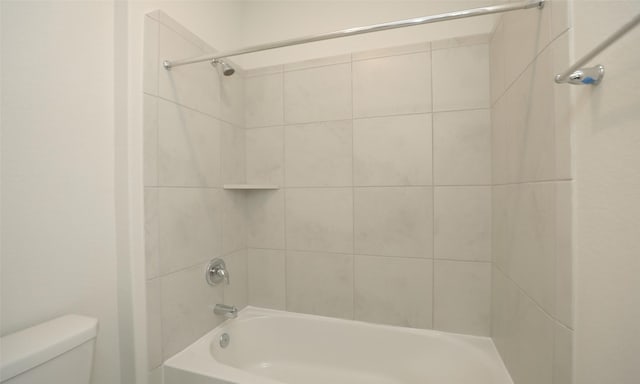 bathroom with tiled shower / bath and toilet