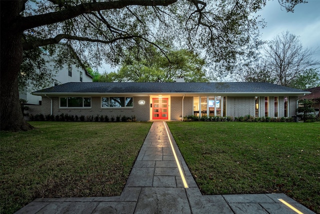 single story home with french doors and a front lawn