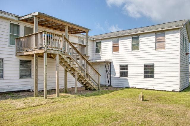 back of property with stairs, a yard, and a wooden deck