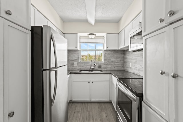 kitchen with hardwood / wood-style flooring, decorative backsplash, sink, a textured ceiling, and stainless steel appliances