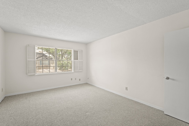 unfurnished room with a textured ceiling and carpet flooring