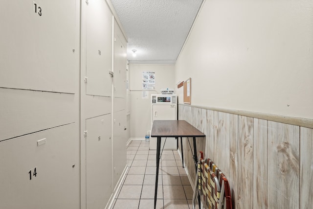 hallway with a textured ceiling and light tile patterned floors