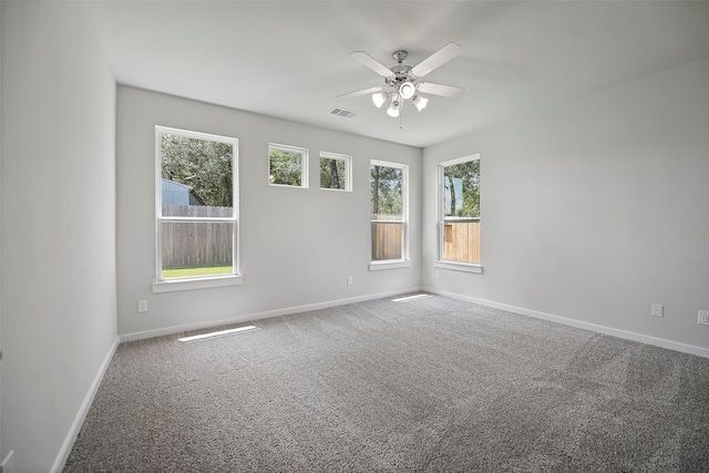 empty room with ceiling fan, carpet floors, and plenty of natural light