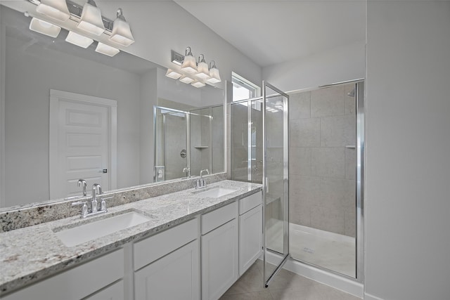 bathroom with a shower with shower door, double vanity, and tile patterned flooring