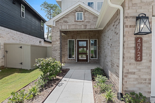 view of exterior entry featuring a lawn