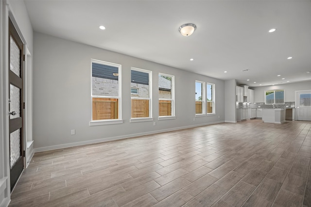 unfurnished living room featuring light hardwood / wood-style floors and sink