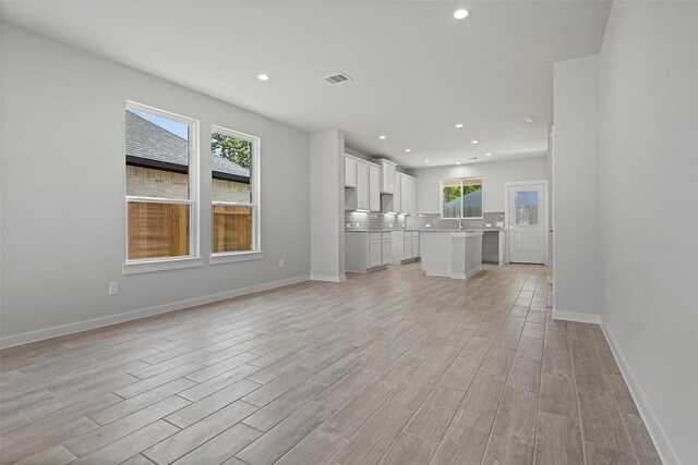 unfurnished living room with light hardwood / wood-style floors and plenty of natural light