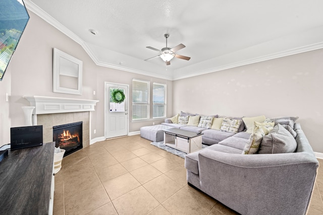 living room with a fireplace, ceiling fan, light tile patterned floors, and ornamental molding