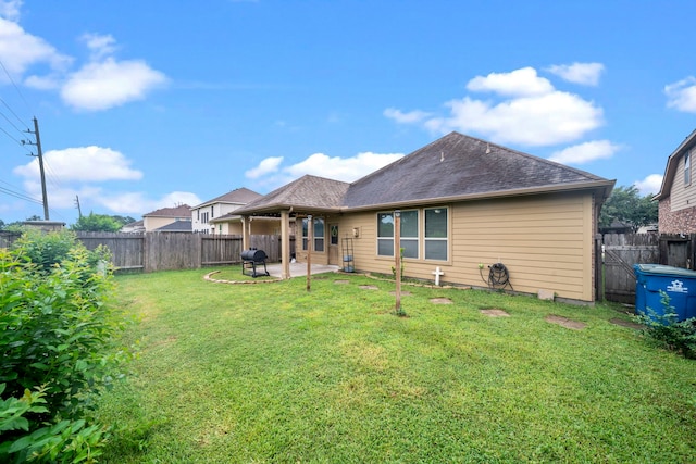 rear view of property featuring a lawn and a patio area