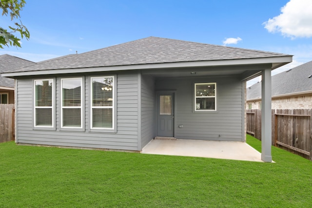 rear view of house with a patio and a yard