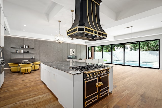 kitchen with custom exhaust hood, black appliances, light hardwood / wood-style floors, pendant lighting, and white cabinets