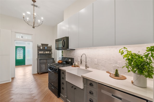 kitchen featuring backsplash, black appliances, pendant lighting, gray cabinets, and white cabinetry