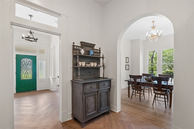 dining area with light parquet floors and a chandelier