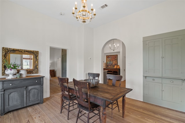 dining room with a towering ceiling and light hardwood / wood-style flooring