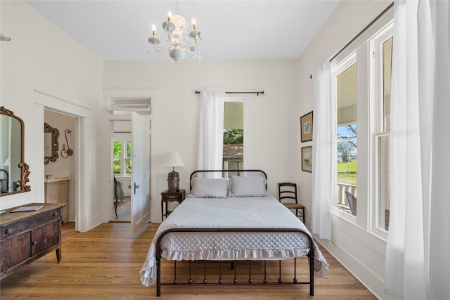 bedroom with a notable chandelier and light hardwood / wood-style flooring