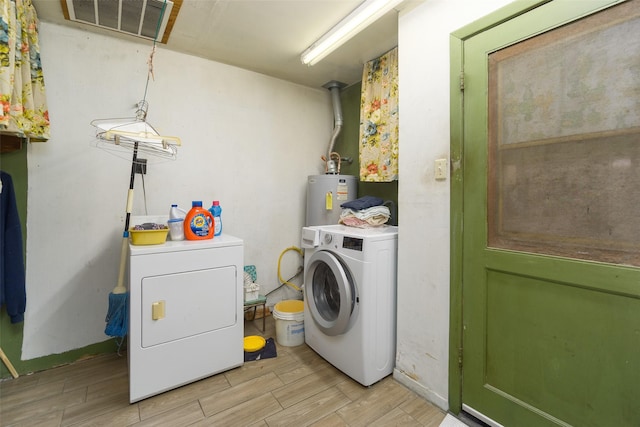 laundry room featuring wood finish floors, water heater, visible vents, washer and dryer, and laundry area