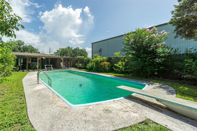 outdoor pool featuring a diving board, a patio area, and fence