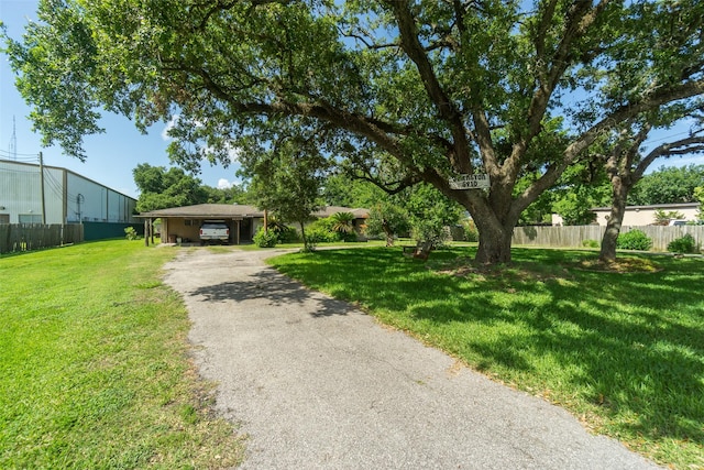 exterior space featuring fence, aphalt driveway, and a front yard