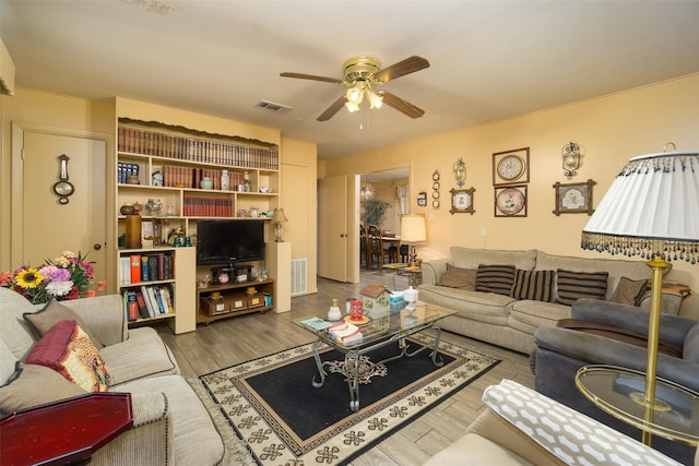 living area featuring ceiling fan, visible vents, and wood finished floors