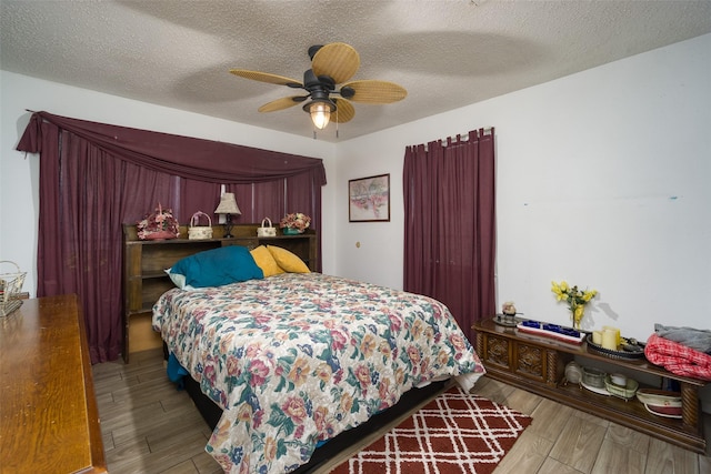 bedroom featuring a textured ceiling, a ceiling fan, and wood finished floors