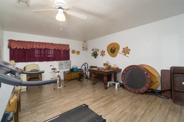 workout room featuring wood finish floors, visible vents, and ceiling fan