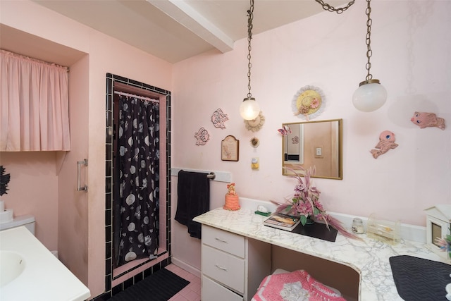 bathroom featuring beam ceiling, a shower stall, and vanity