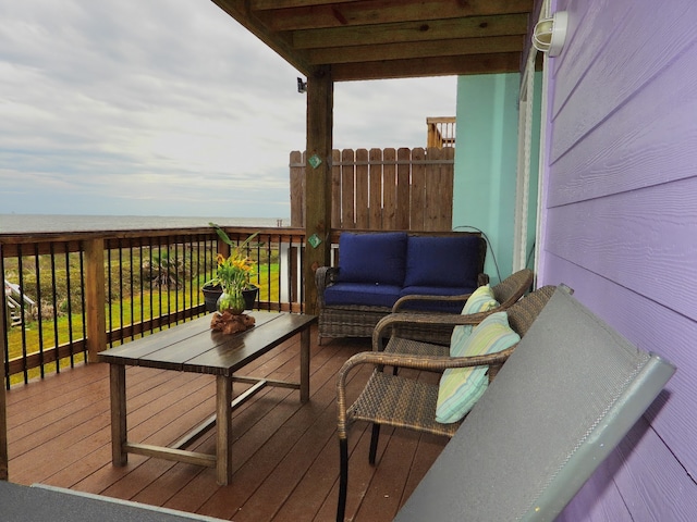 deck with a water view and outdoor lounge area