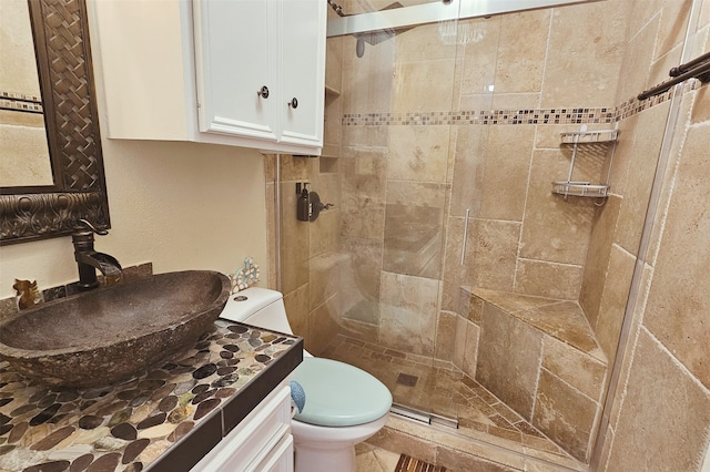 bathroom with walk in shower, vanity, and toilet