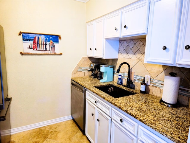 kitchen with white cabinets, sink, tasteful backsplash, stainless steel dishwasher, and dark stone counters