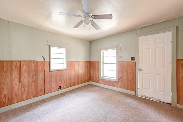 empty room with a healthy amount of sunlight, carpet flooring, and ceiling fan