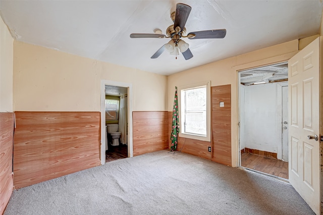 unfurnished bedroom featuring ensuite bath, ceiling fan, and carpet flooring