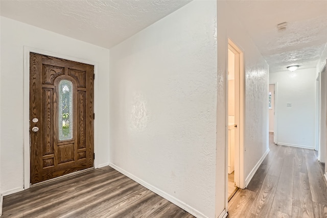 foyer featuring dark hardwood / wood-style flooring and a textured ceiling