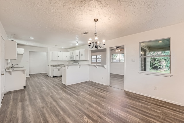 kitchen featuring white cabinets, dark hardwood / wood-style floors, pendant lighting, and kitchen peninsula