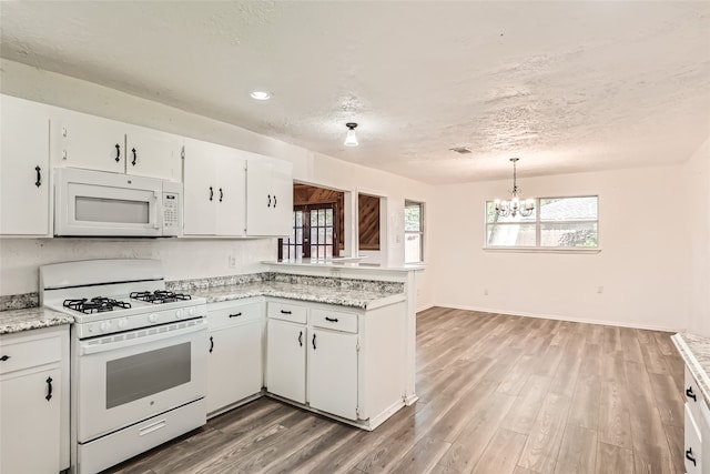 kitchen featuring white cabinets, a notable chandelier, white appliances, and light hardwood / wood-style flooring