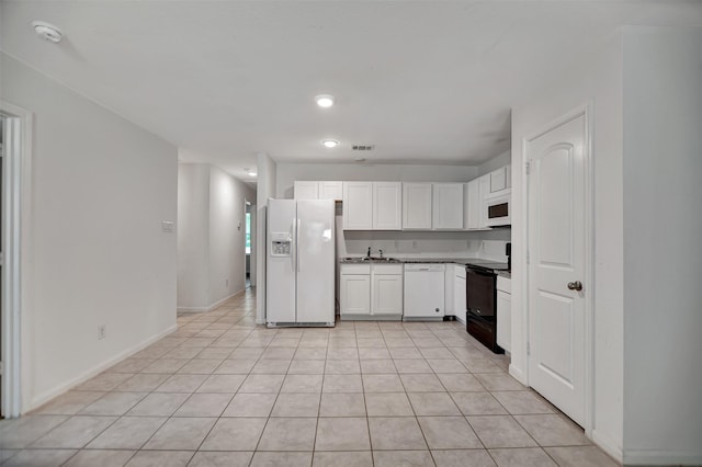 kitchen featuring sink, white cabinetry, white appliances, and light tile patterned floors