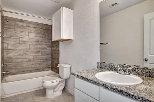 full bathroom featuring tiled shower / bath combo, vanity, toilet, and tile patterned flooring