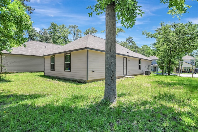 view of property exterior featuring central air condition unit and a lawn