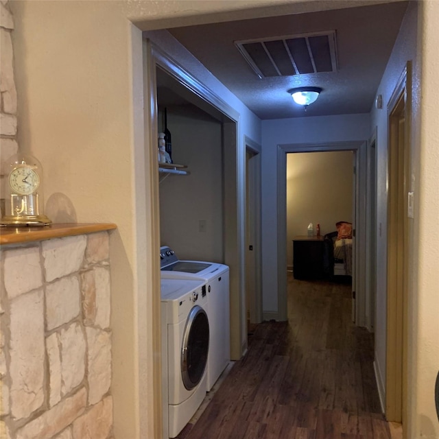 laundry room featuring washer and clothes dryer and dark wood-type flooring