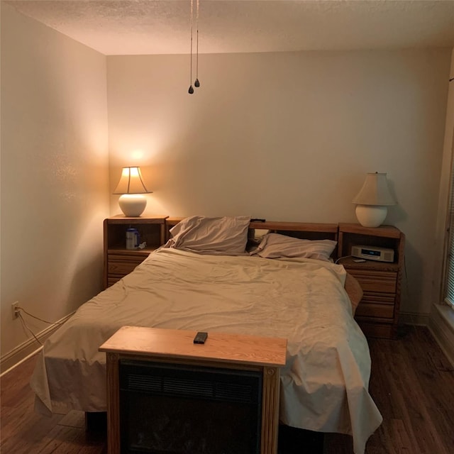 bedroom with dark hardwood / wood-style floors