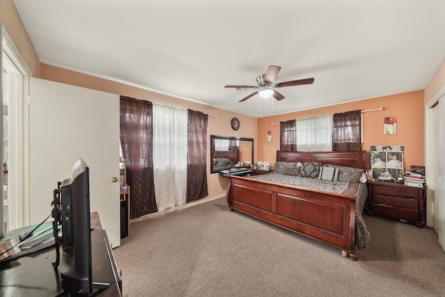 carpeted bedroom with ceiling fan and multiple windows