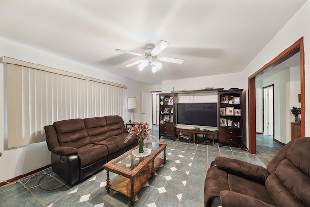 living area featuring ceiling fan, baseboards, and tile patterned floors