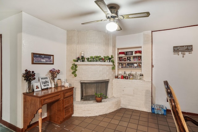 interior space with a brick fireplace, dark tile patterned floors, built in features, and a ceiling fan