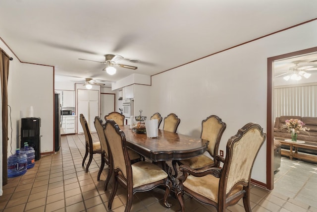 dining room with crown molding, ceiling fan, and light tile patterned floors