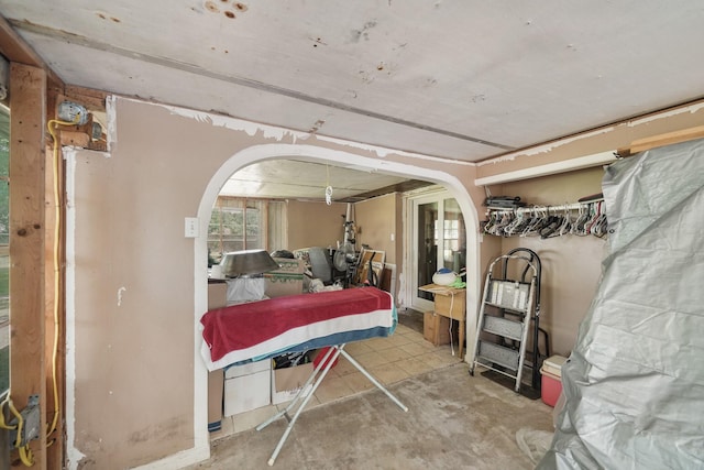 bedroom featuring concrete flooring and arched walkways