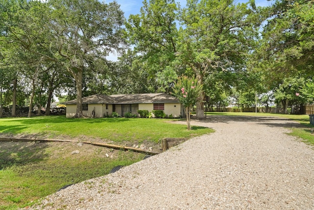 ranch-style home with driveway, a front lawn, and fence