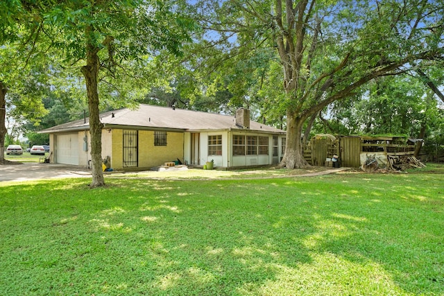 ranch-style home with a garage, brick siding, a chimney, and a front yard