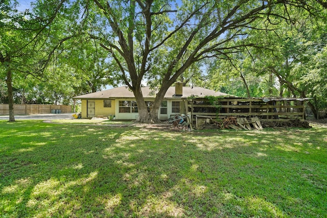 back of house featuring fence and a yard