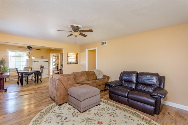 living room with ceiling fan and wood-type flooring