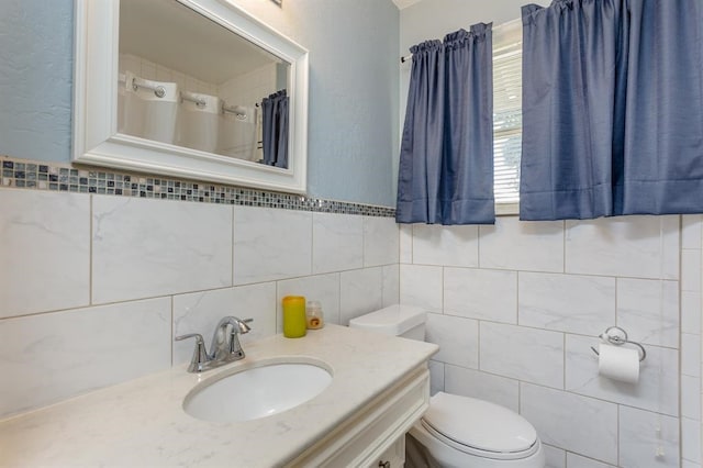 bathroom featuring large vanity, tasteful backsplash, toilet, and tile walls